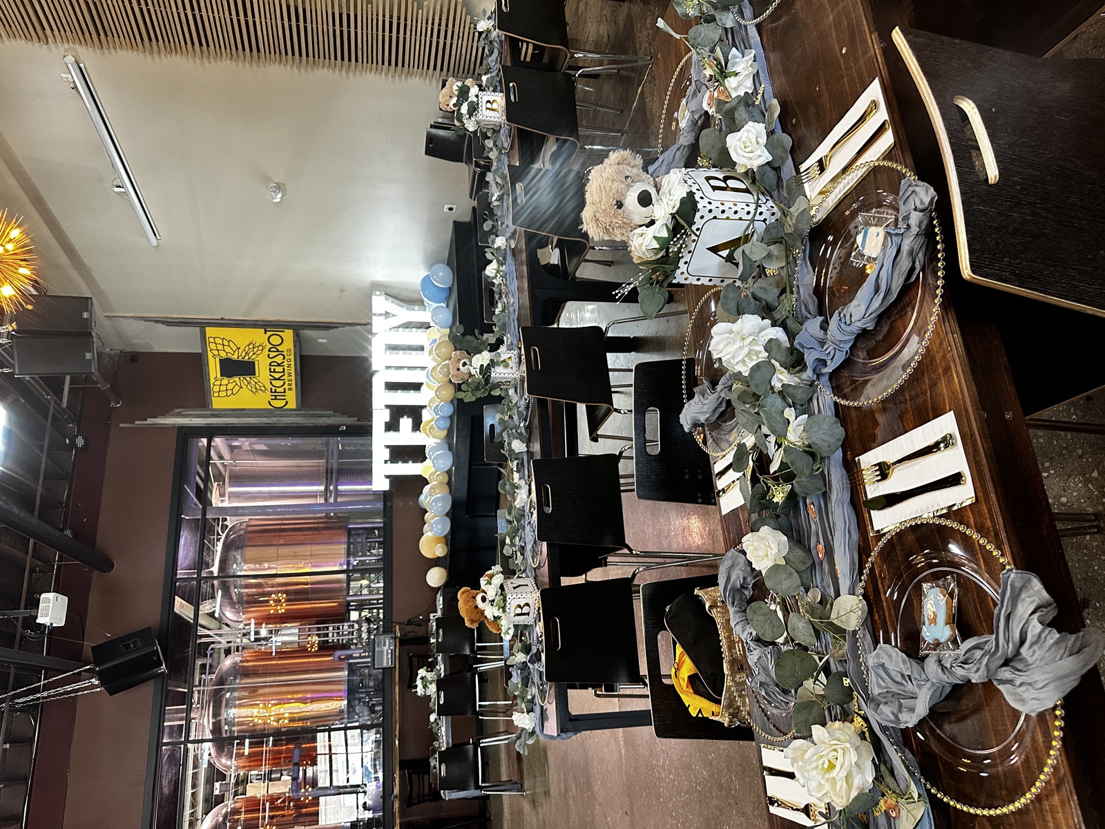 An elegant private-party table setting with the brewhouse tanks behind