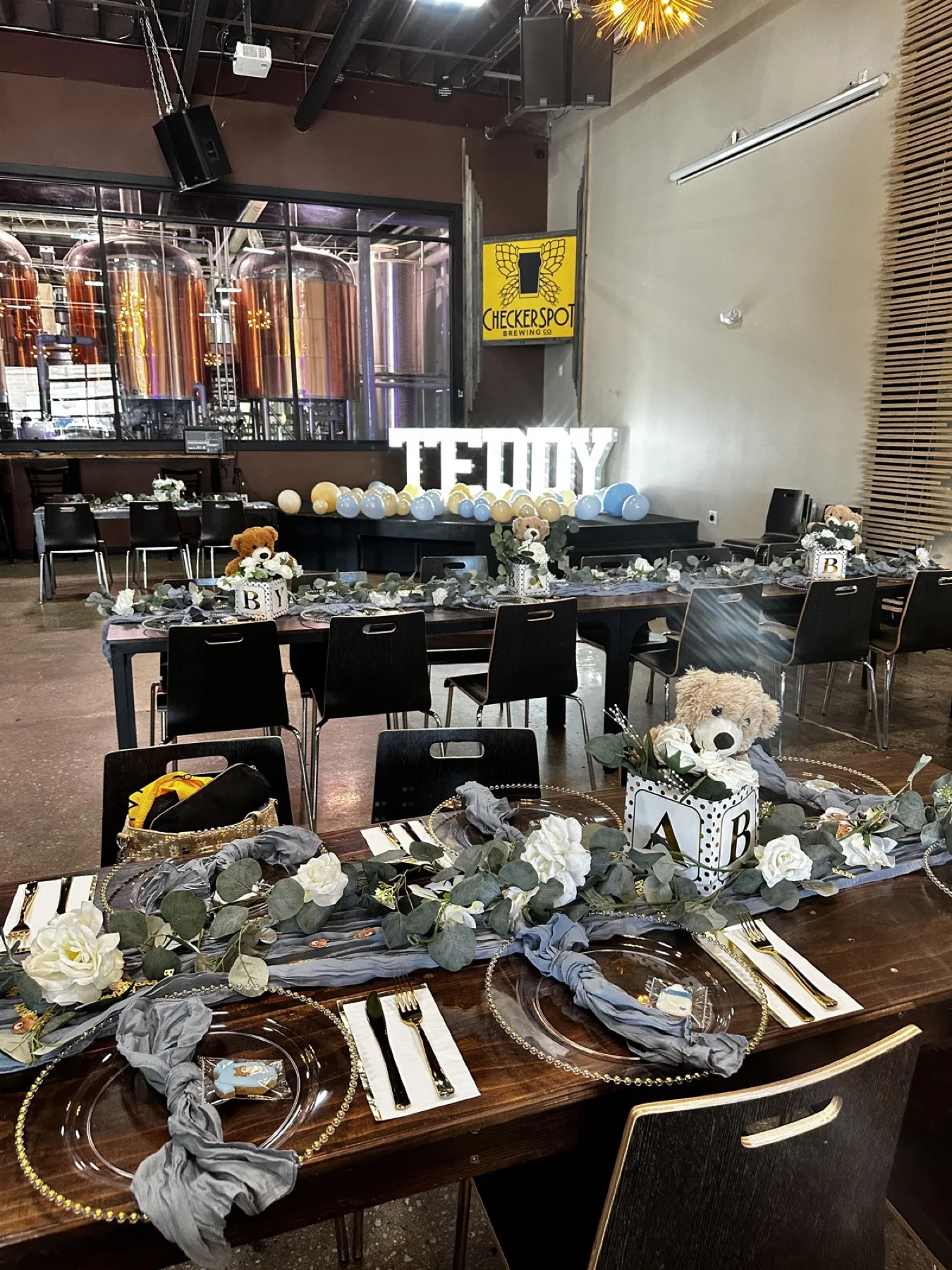 An elegant private-party table setting with the brewhouse tanks behind