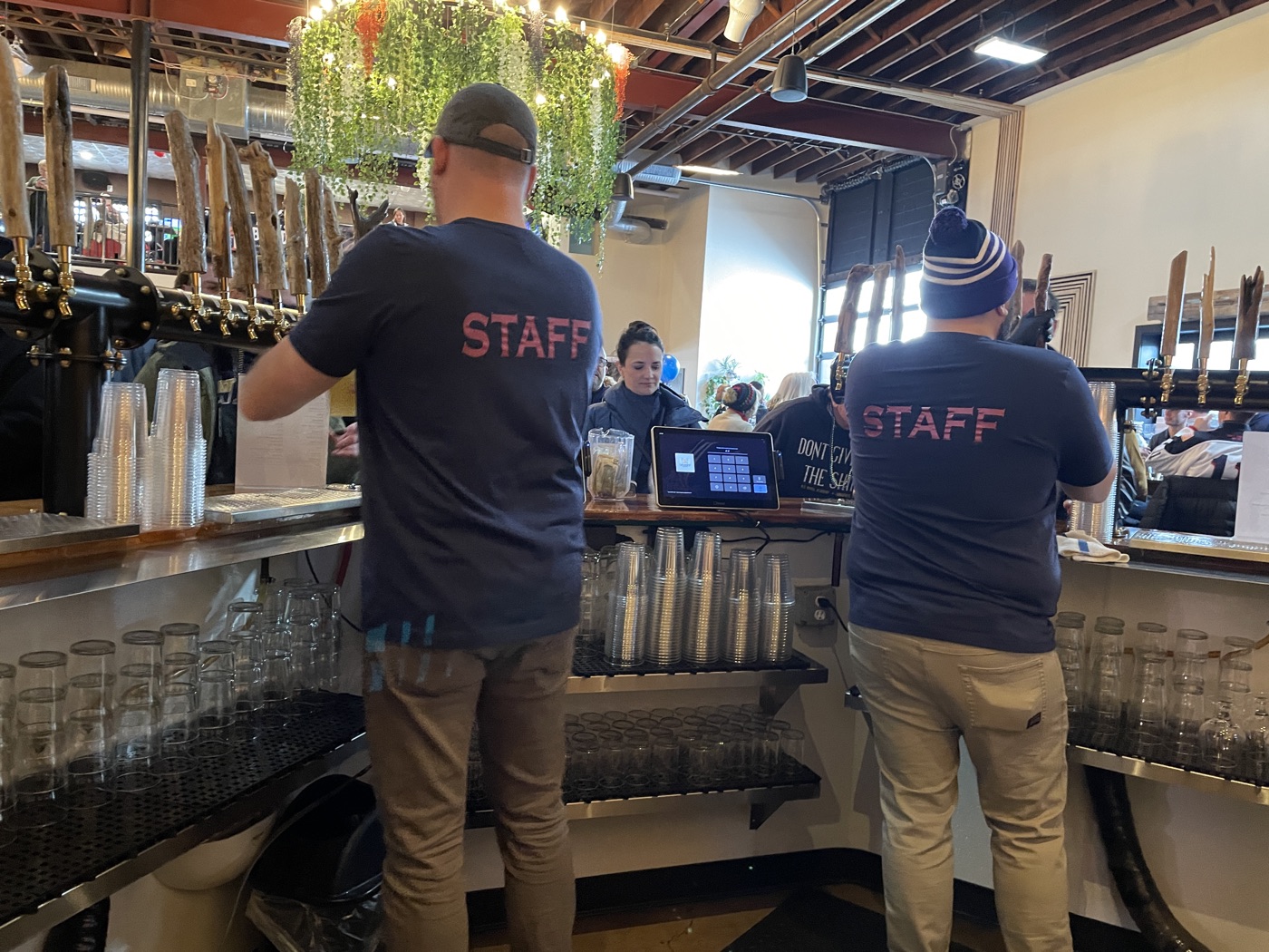 Staff pouring beers behind the Checkerspot bar